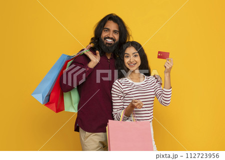 Happy indian spouses with purchases and credit card 112723956