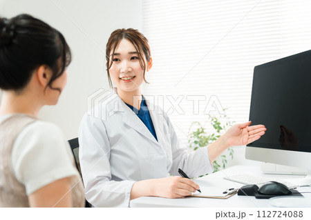病院・クリニックでパソコンを使って診察・診療・説明・問診をする医師・医者の女性と患者の写真素材 [112724088] - PIXTA