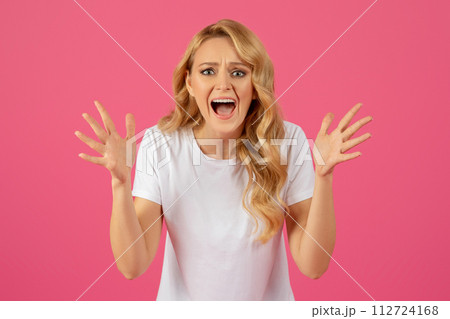 Angry sad young blonde woman screaming over pink studio background 112724168