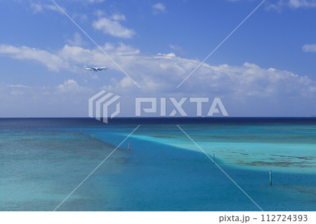 青い海を背景に那覇空港へ着陸する航空機 112724393