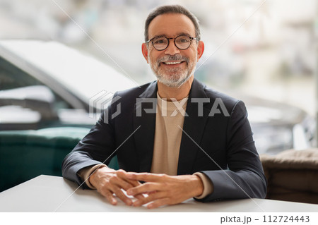 Confident and friendly senior businessman with glasses, smiling at the camera 112724443