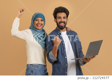 Happy excited muslim couple with laptop celebrating success 112724577