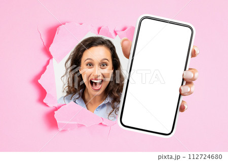 Cheerful shocked excited young european woman with open mouth showing smartphone with empty screen 112724680