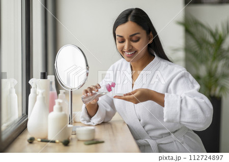 Pretty hindu woman using tonner, cleansing her beautiful skin Pretty hindu woman using tonner, cleansing her beautiful skin 112724897