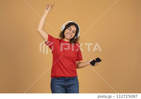 Joyful young middle eastern woman listening to music 112725097