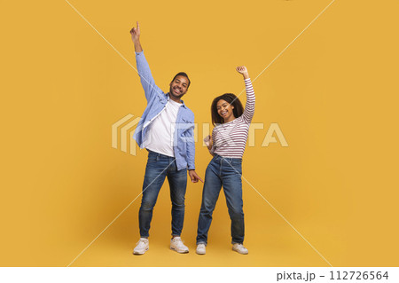 Positive young african american couple in casual outfits dancing together 112726564