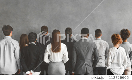 Business team looking at grey wall with empty space 112726606