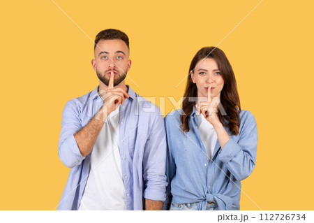 Quiet gesture, couple with fingers on lips 112726734