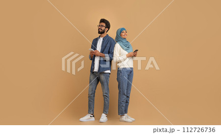 Portrait Of Young Muslim Couple With Smartphones Looking At Copy Space 112726736