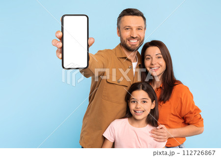 Cheerful Caucasian Family Showing Mobile Phone With Blank Screen, Studio 112726867
