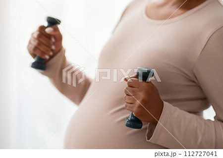 Cropped of expecting black woman exercising with barbells 112727041