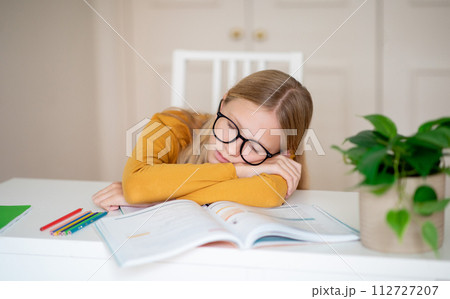 Portrait Of Teen Girl Sleeping At Desk, Tired After Doing School Homework Portrait Of Teen Girl Sleeping At Desk, Tired After Doing School Homework 112727207