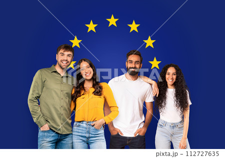 Two smiling couples in casual attire posing confidently against a deep blue background 112727635
