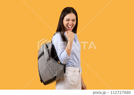 Joyful female student celebrating with fist pump, feeling victorious and happy Joyful female student celebrating with fist pump, feeling victorious and happy 112727880