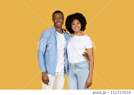 A cheerful young African American couple posing with bright smiles A cheerful young African American couple posing with bright smiles 112727919