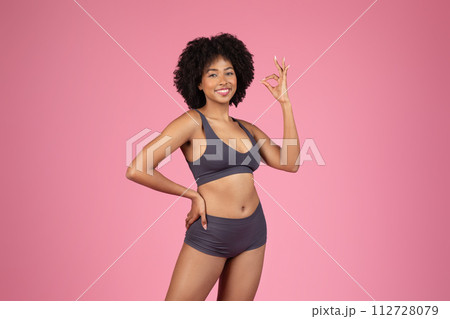 Happy black woman in underwear attire showing OK sign 112728079
