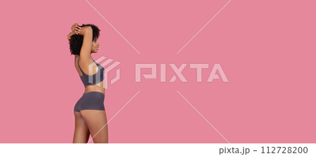 Black fit woman stretching arms in underwear, top and shorts, free space Black fit woman stretching arms in underwear, top and shorts, free space 112728200