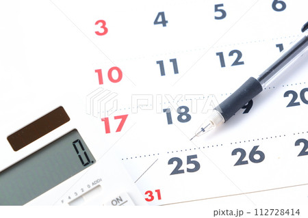 カレンダーを眺めながら電卓を叩いて、25日の給料日を待ち望んでいるイメージ 112728414