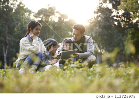 happy asian family having a good time outdoors in city park happy asian family having a good time outdoors in city park 112728978