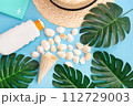 Summer holidays with seashells, palm leaves and straw hat. Blue background. Top view, flat lay. 112729003