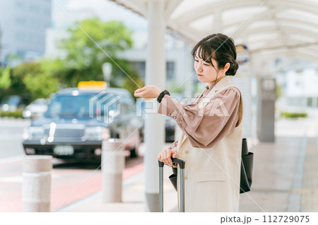 駅・ターミナル・バス停で腕時計で時間を確認する若いビジネスウーマン（遅刻・遅れる・焦る・イライラ） 112729075