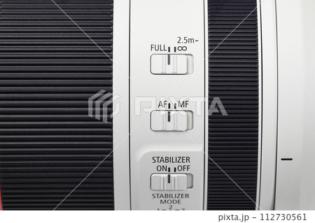 Distance switch, Manual/auto focus switch button set to "Auto focus" and stabilizer switch button mode set to "on" on profession camera lens. 112730561