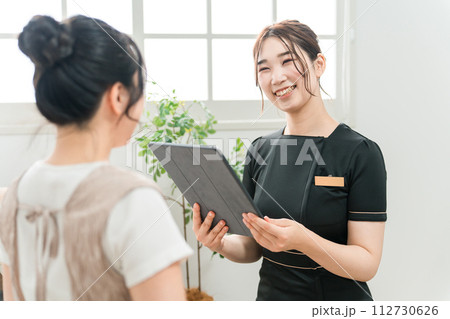 エステサロンでタブレットPCを使ってカウンセリングする エステサロンでタブレットPCを使ってカウンセリングする 112730626