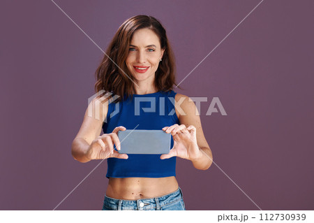 Portrait of slim fit woman filming or taking photos on smartphone 112730939