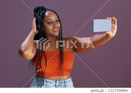 Smiling Black young woman taking selfie for social media 112730964
