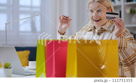 A senior woman is receiving goods instantly after online shopping, thanks to express delivery A senior woman is receiving goods instantly after online shopping, thanks to express delivery 112731355