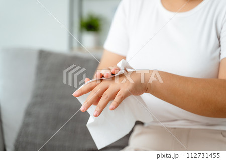 A woman is wiping her hands with a paper towel 112731455