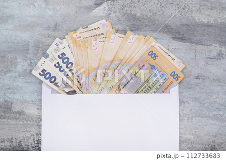 Ukrainian hryvnia in a white envelope on a stone background. Copy of space. 500 hryvnias. Concept of payment or corruption 112733683