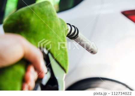 hand refilling a car with fuel at a gas station hand refilling a car with fuel at a gas station 112734022