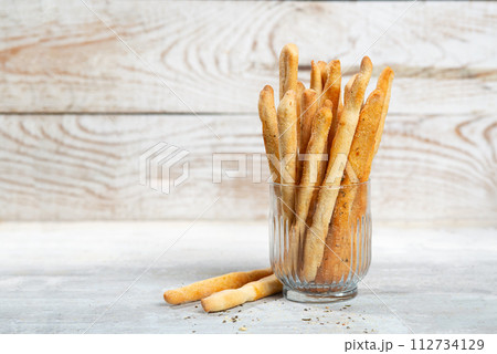 Grissini with herbs on a gray concrete background 112734129