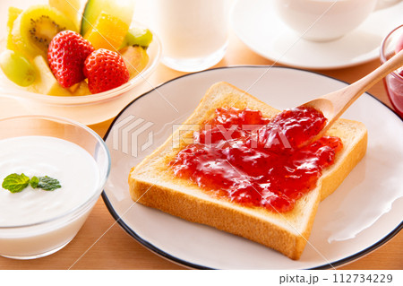 トーストにイチゴジャムを塗る 112734229