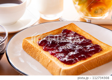 トーストにブルーベリージャムを塗る 112734308