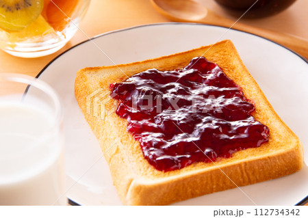 トーストにブルーベリージャムを塗る 112734342