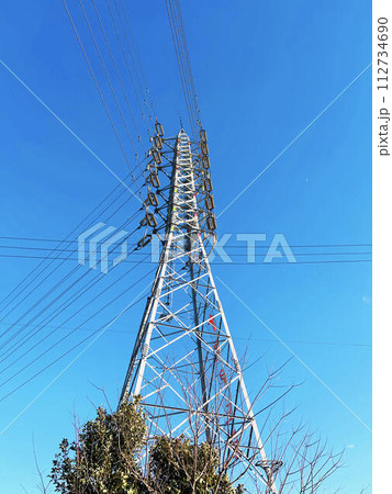 送電線と青空と木々 112734690