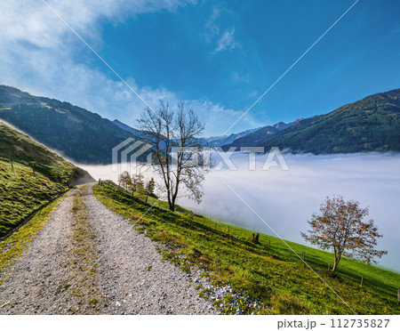 Peaceful misty autumn morning mountain view from hiking path from Dorfgastein to Paarseen lakes, Land Salzburg, Austria. Peaceful misty autumn morning mountain view from hiking path from Dorfgastein to Paarseen lakes, Land Salzburg, Austria. 112735827
