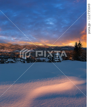 Alpine village outskirts in last evening sunset sun light. Winter snowy hills and fir trees. High resolution stitch image with great depth of field. Alpine village outskirts in last evening sunset sun light. Winter snowy hills and fir trees. High resolution stitch image with great depth of field. 112735849