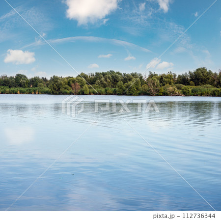 Summer hazy day on picturesque lake 112736344