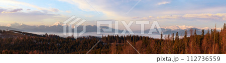 Spring dusk Carpathian mountains landscape with snow-covered ridges in far, Ukraine. From left to right - Hoverla, Petros, Blyznycja tops. Spring dusk Carpathian mountains landscape with snow-covered ridges in far, Ukraine. From left to right - Hoverla, Petros, Blyznycja tops. 112736559