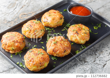 Perkedel Kentang is Potato croquette of ground meat and boiled potatoes with sauce closeup on the plate. Horizontal Perkedel Kentang is Potato croquette of ground meat and boiled potatoes with sauce closeup on the plate. Horizontal 112736882