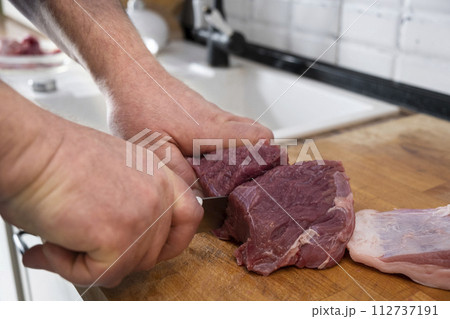 Real men cutting fresh raw meat on board in white kitchen. Preparing pork meat, cooking 112737191