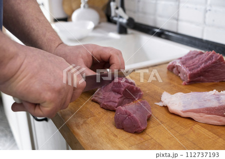 Real men cutting fresh raw meat on board in white kitchen. Preparing pork meat, cooking 112737193