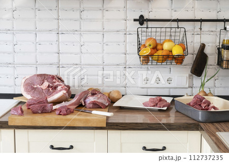 Different tipes of meat. Banner, cutting fresh raw meat on board in white kitchen. Preparing pork meat, cooking Different tipes of meat. Banner, cutting fresh raw meat on board in white kitchen. Preparing pork meat, cooking 112737235