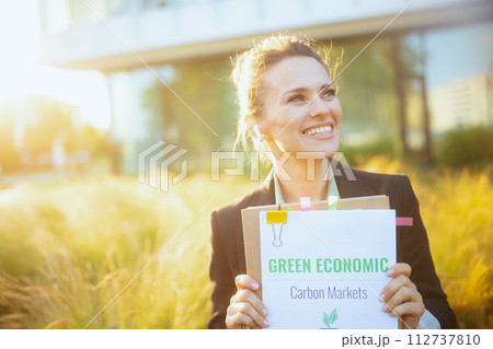 happy modern woman worker near business center in black jacket 112737810