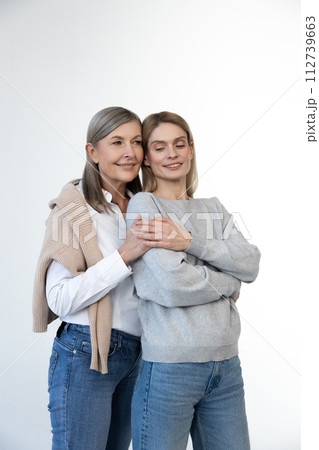 Blonde woman and her mom looking contented and confident Blonde woman and her mom looking contented and confident 112739663