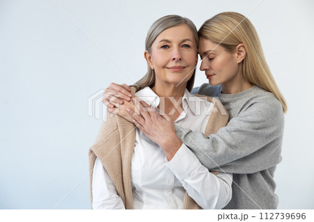 Waist up picture of mom and daughter embracing 112739696