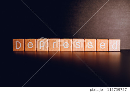 Wooden blocks form the text "Depressed" against a black background. Wooden blocks form the text "Depressed" against a black background. 112739727